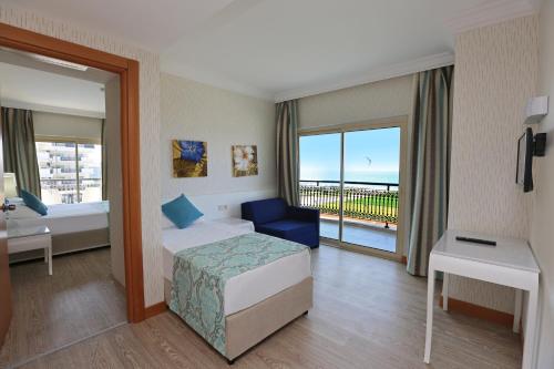una camera d'albergo con un letto e un balcone di Asteria Bloom Side a Kızılağaç
