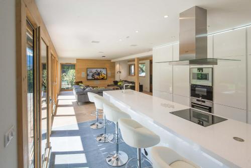 une cuisine avec un comptoir blanc et des tabourets dans l'établissement Chalet Montana- Chamonix All Year, à Chamonix-Mont-Blanc