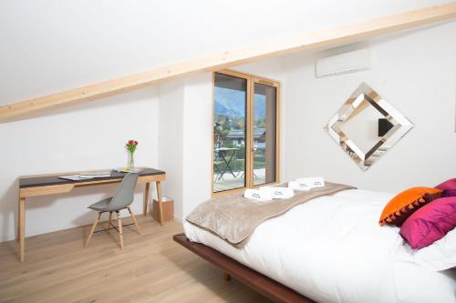 a bedroom with a bed and a desk and a window at Chalet Montana- Chamonix All Year in Chamonix-Mont-Blanc