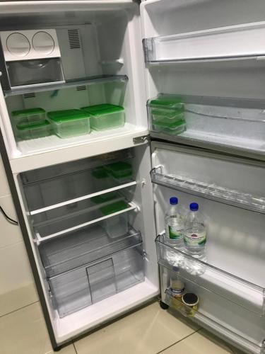 a refrigerator with its door open with water bottles in it at SINGGAH Putrajaya - 3 Bedrooms with Pool and KL View in Putrajaya