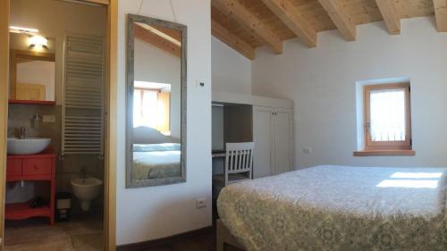 a bedroom with a bed and a sink and a mirror at B&B Contrade Alte in SantʼAnna dʼAlfaedo