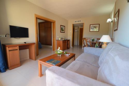 a living room with a couch and a tv at Bahía Tropical in Almuñécar