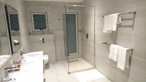 a bathroom with a shower and a toilet and a sink at Hamilton Garden Suites in Parklands