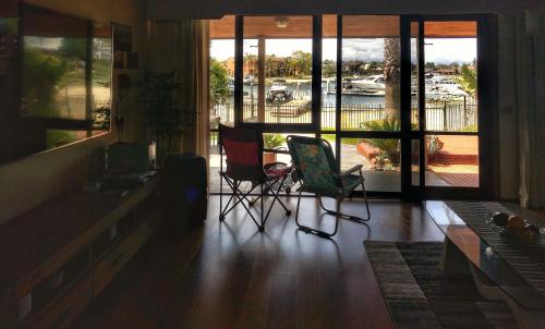 a living room with two chairs and a large window at Waterfront Retreat in Carrum