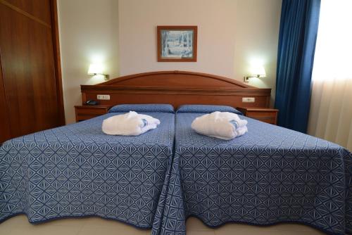 two towels on a bed in a hotel room at Bahía Tropical in Almuñécar