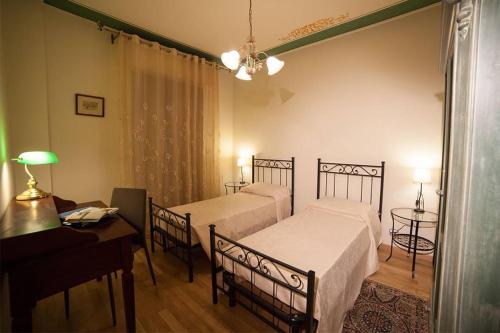 ヴェローナにあるDimora Il Corsoのベッドルーム1室(ベッド2台、デスク、ピアノ付)