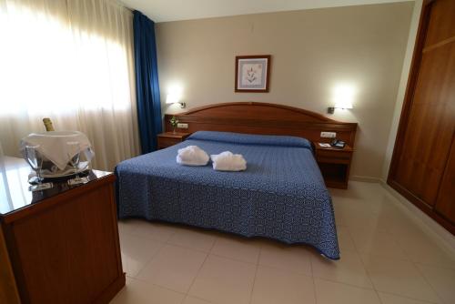 a bedroom with a bed with two towels on it at Bahía Tropical in Almuñécar