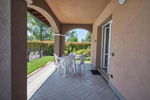 a patio with a white table and chairs on it at Villaggio Turistico Lugana Marina in Sirmione
