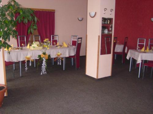 a dining room with white tables and chairs at Penzion U Kašných in Mníšek pod Brdy