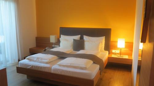 a bedroom with a large bed with white pillows at Apparthotel Gartenresidence Nalserhof in Nalles
