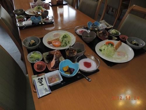 a table with several plates of food on it at Naeba Lodge Oka in Yuzawa