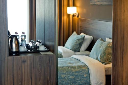 two pictures of a hotel room with a bed and a table at Sky Inn Batumi in Batumi