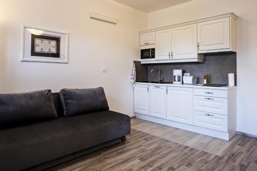 a living room with a couch and a kitchen at Vila Mila in Bled