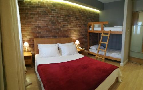 a bedroom with a bed and a brick wall at Amaryllis in Nafpaktos