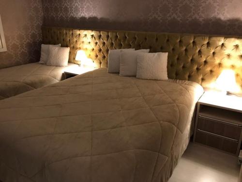 a bedroom with a large bed with two night stands at Altos da Bela Vista Gramado centro locação de temporada in Gramado