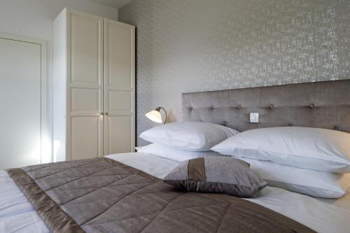 a bedroom with a large bed with white pillows at Vila Mila in Bled