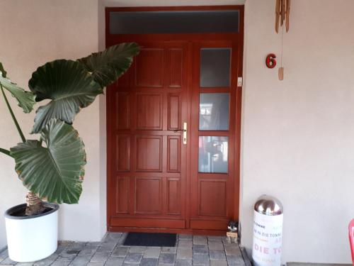 a red door with a plant in front of it at Kertvárosi Apartman in Tiszaújváros
