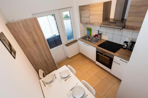 a small kitchen with a table and chairs in it at AVR Apartment HOF 8 in Bremerhaven