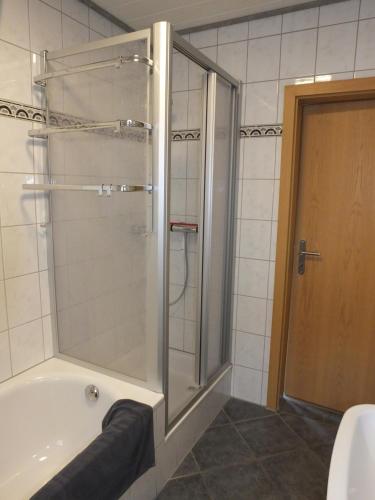 a bathroom with a shower and a bath tub at Ferienwohnung Baumberge in Nottuln
