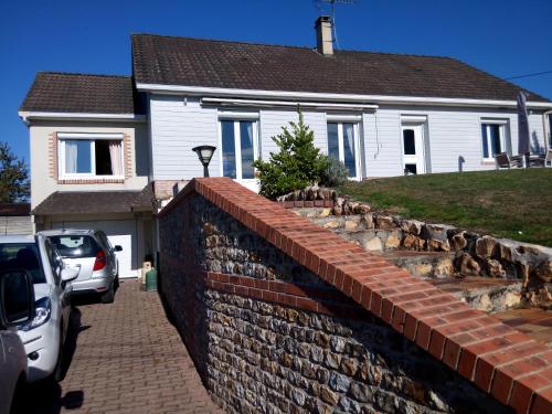 a brick retaining wall in front of a house at La Risloise in Corneville-sur-Risle