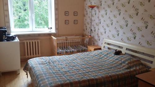 a bedroom with a bed with a blue plaid blanket at Harmony Life Two-room apartment in Riga in Riga