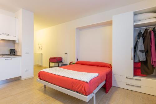 トスコラーノ・マデルノにあるPiantù Homeのベッドルーム1室(赤いベッド1台付)、キッチンが備わります。