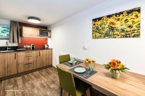 a kitchen with a wooden table with chairs and a counter at Übernachten in der Tenne in Nürnberg