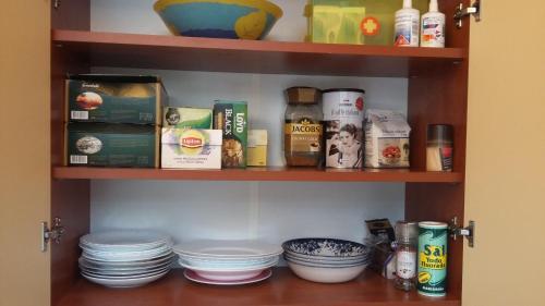 a shelf with dishes and other food items on it at Harmony Life Two-room apartment in Riga in Rīga
