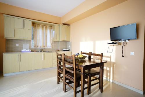 a kitchen with a table and chairs and a television at Apartments Vila Emiliano in Borsh