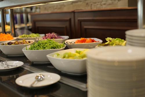 a buffet with bowls of vegetables on a table at Tolip Inn Maadi in Cairo