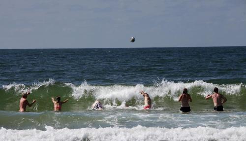 a group of people playing in the ocean at Dancamps Nordsø Camping (Camp Site) in Hvide Sande