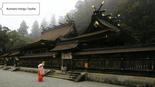 a person standing in front of a building at Kumano Kodo Nagano Guesthouse in Tanabe