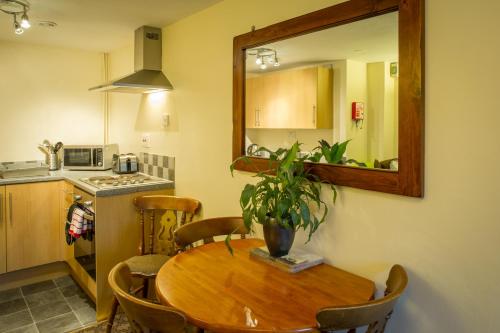 a kitchen with a wooden table and a mirror at The Old Nag's Head in Edale