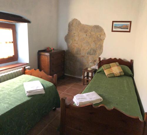 a bedroom with two beds and a window at Podere Mazzarelle in Castel del Piano