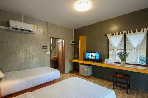 a bedroom with two beds and a television in it at Chiang Dao Reset in Chiang Dao