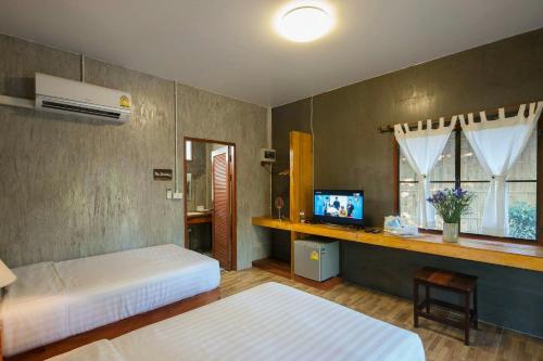 a bedroom with two beds and a television in it at Chiang Dao Reset in Chiang Dao