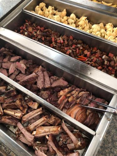 a bunch of different types of meats and other foods at Center Hotel in Imbé