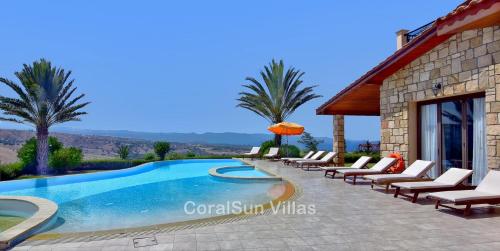 a villa with a swimming pool and lounge chairs at ELITE Amazing Villa, by Coral Sun Villas in Polis Chrysochous