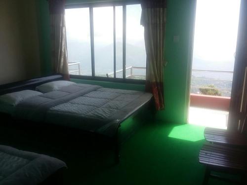 a bedroom with a bed in front of a window at Himalayan crown lodge in Pokhara