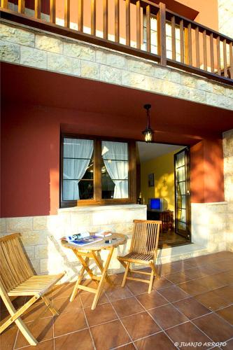 a patio with two chairs and a table and a balcony at Apartamentos Rurales Argame in Argamé