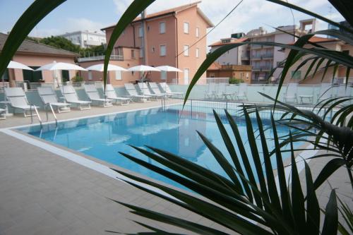 une piscine avec des chaises et un hôtel dans l'établissement Hotel Albatros, à Lido di Jesolo