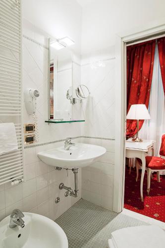 a white bathroom with a sink and a mirror at Hotel al Graspo de Ua in Venice
