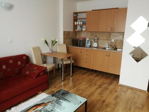 a living room with a red couch and a kitchen at ANGEL´S VENDÉGHÁZ in Eger