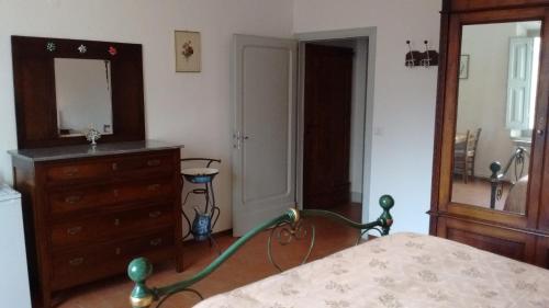 a bedroom with a bed and a dresser and a mirror at San Lorenzo in Cerreto dʼEsi