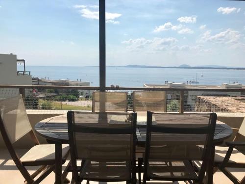 a table and chairs on a balcony with a view of the ocean at Quartier Punta Ballena 2 dorm en suite in Punta del Este