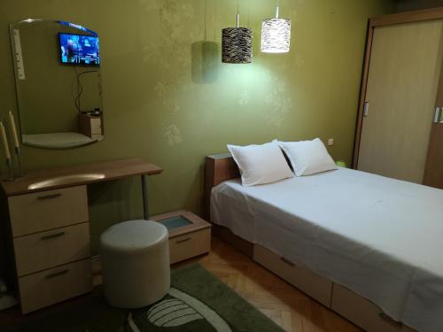 a bedroom with a bed and a desk and a mirror at Стаи за гости "Панега" in Pleven