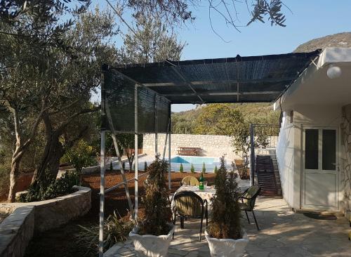 a pavilion with chairs and a table in a yard at Apartman Nikocevic in Dobra Voda