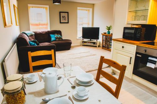 a kitchen and living room with a table and chairs at Atrium apartment B in Bangor