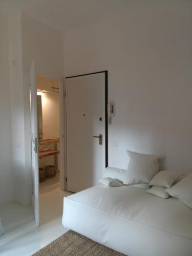 a white bedroom with a large white bed and a mirror at BED and BIKE - BERGAMO Old Town in Bergamo