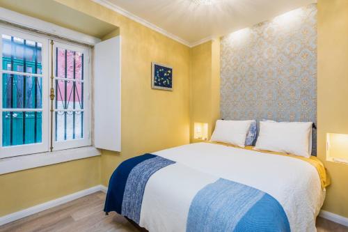 1 dormitorio con 1 cama y 2 ventanas en Brand new and cozy Alfama Experience, en Lisboa